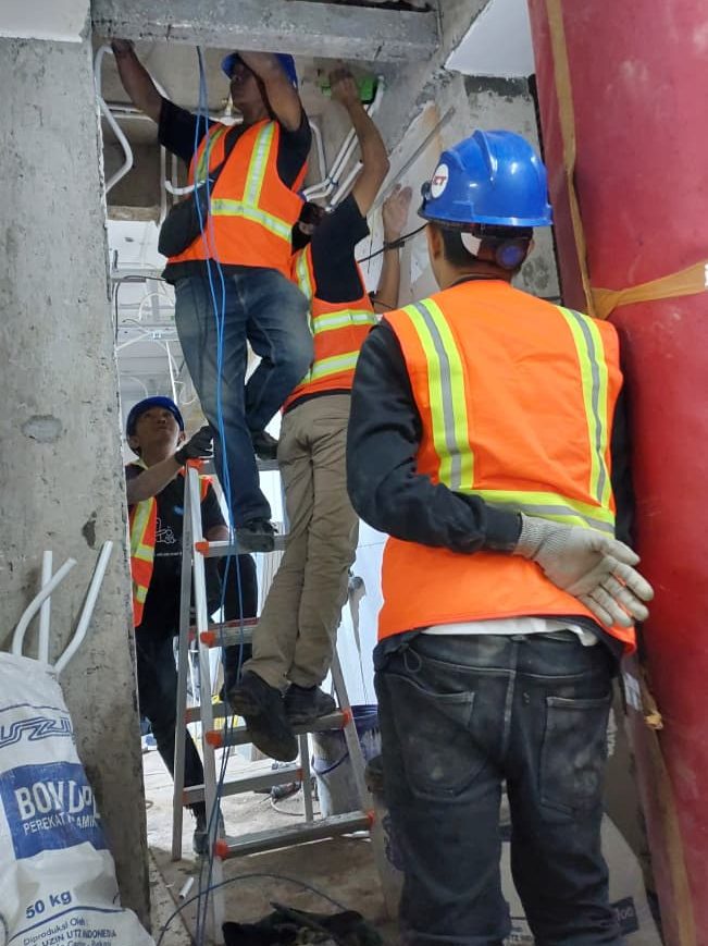 Para teknisi cctv dari radiana cctv sedang melakukan instalasi kabel cctv di hotel padma bandung menggunakan APD lengkap