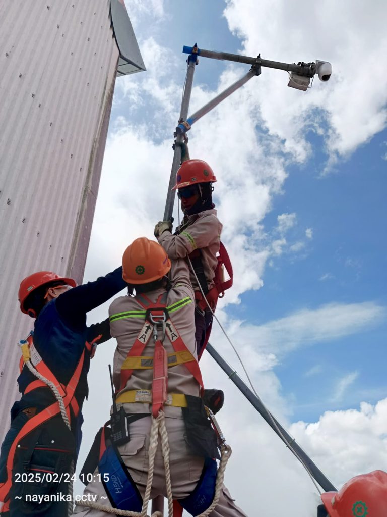 para teknisi dari radiana cctv sedang melakukan instalasi cctv di ketinggian kota bandung lengkap menggunakan alat pelindung diri sesuai dengan standart K3